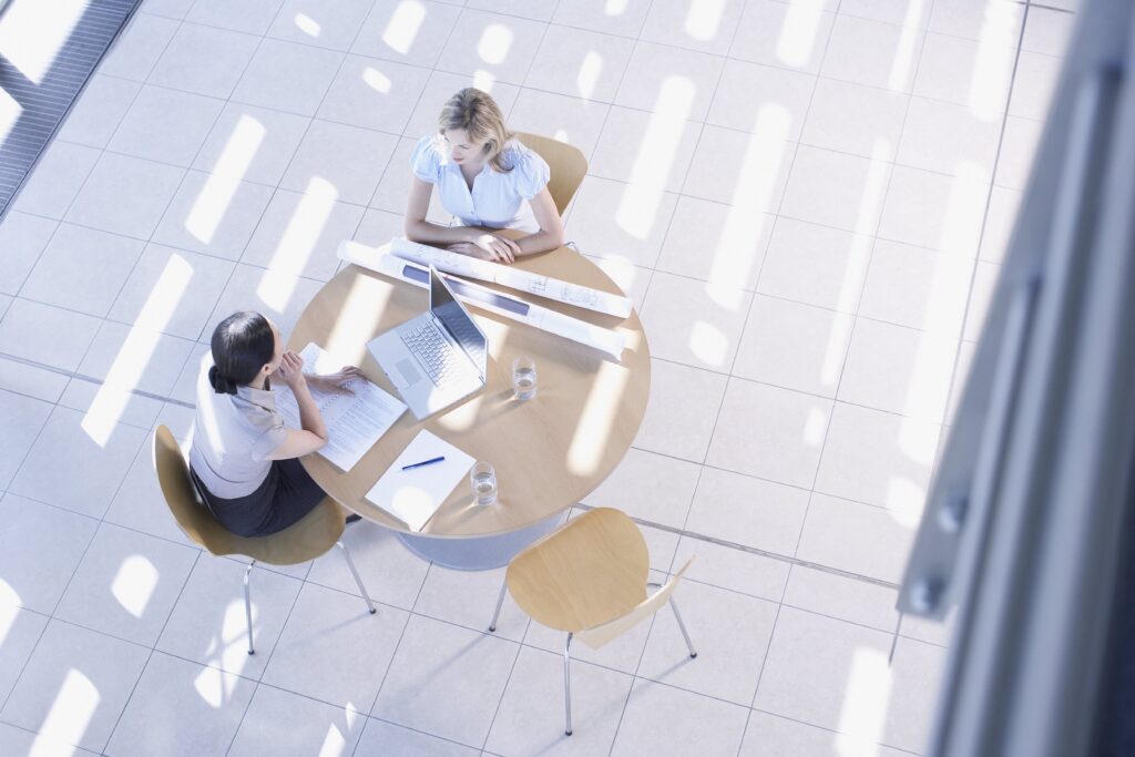 Frauen am Tisch mit Notebook und Plänen