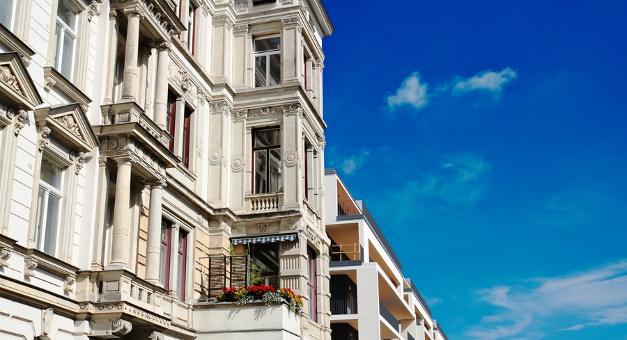 Altbau- und Neubaufassade bei blauem Himmel